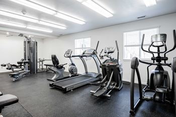 A gym with treadmills, elliptical machines, and other exercise equipment